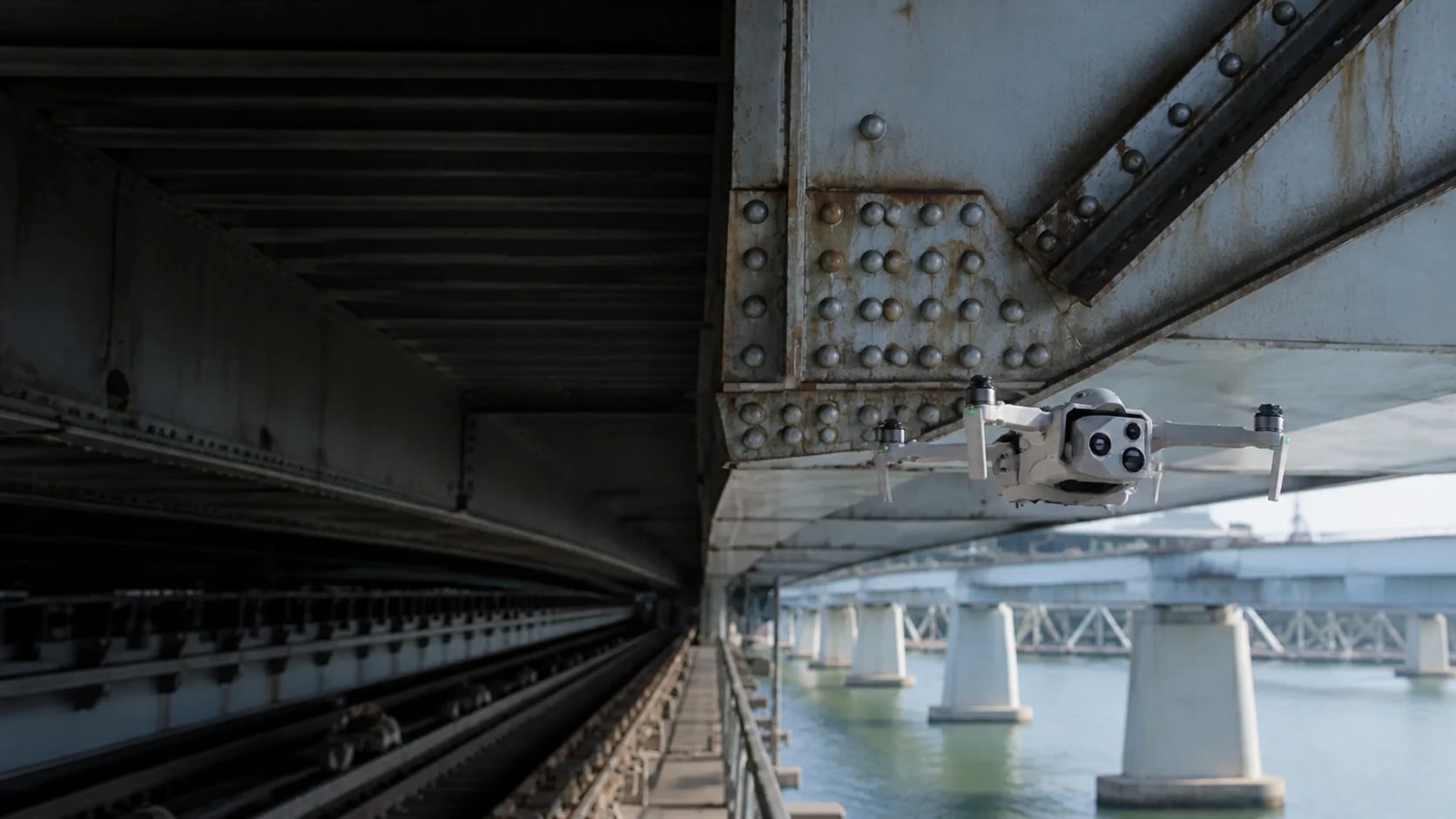 Skydio X10D inspecting a riveted steel connection beneath a highway bridge