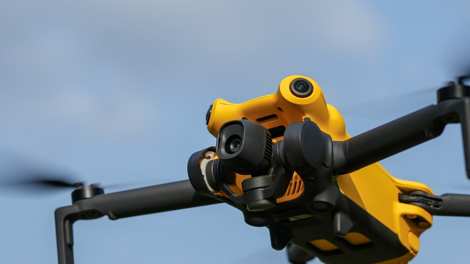 Yellow SkyRover X1 camera drone flying against a blue sky