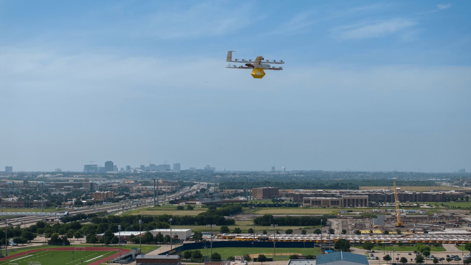 Wing delivery aircraft carrying a package above the Houston metropolitan area